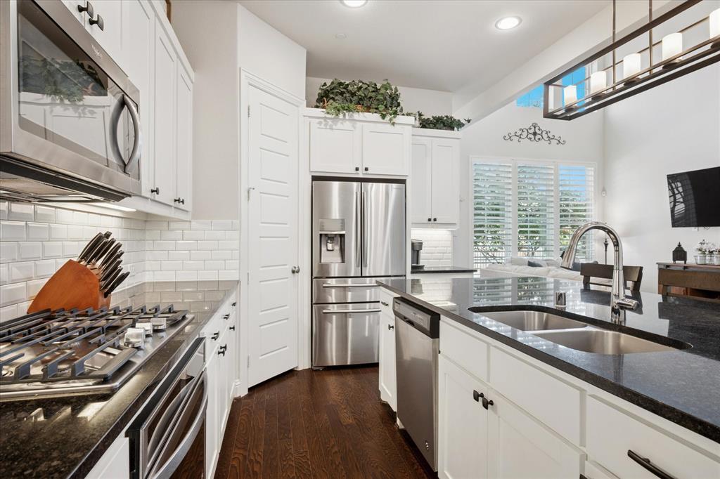 Reduced 40k! Also with an assumable 2.5% interest rate, yes TWO POINT FIVE!!! Welcome to this beautifully appointed 4-bedroom, 3.5-bath townhome that blends comfort, style, and functionality. Featuring a striking brick and stone elevation and landscaped front yard, this home offers incredible curb appeal from the start. Step inside to discover an open-concept layout with tall ceilings and tons of natural light that floods the main living area. The wrought iron staircase adds a touch of elegance, while the second-floor overlook gives the space an airy, architectural feel. Upstairs, a spacious flex space provides endless possibilities for a game room, home office, or media lounge. The heart of the home is the gourmet kitchen with granite countertops, complete with a large island, stainless steel appliances, gas cooktop, walk-in pantry, and stylish finishes — all seamlessly flowing into the living room for easy entertaining. Retreat to the expansive primary suite, featuring a large walk-in closet and a luxurious en-suite bath with a stand-alone soaking tub, separate shower, and dual vanities. As you walk around, notice the 4 inch plantation shutters! All bedrooms are carpeted for added comfort, and the home includes three full baths and one half bath, ideal for family living or hosting guests. Enjoy your private outdoor living space with a covered back porch on, low-maintenance turf grass, and fully fenced yard, perfect for pets, kids, or quiet evenings outdoors. Additional conveniences include rear parking for easy access and added privacy. Easy access to 121 and 75, and is a perfect lock and leave property. Priced under countu appraisal value by almost 30k!