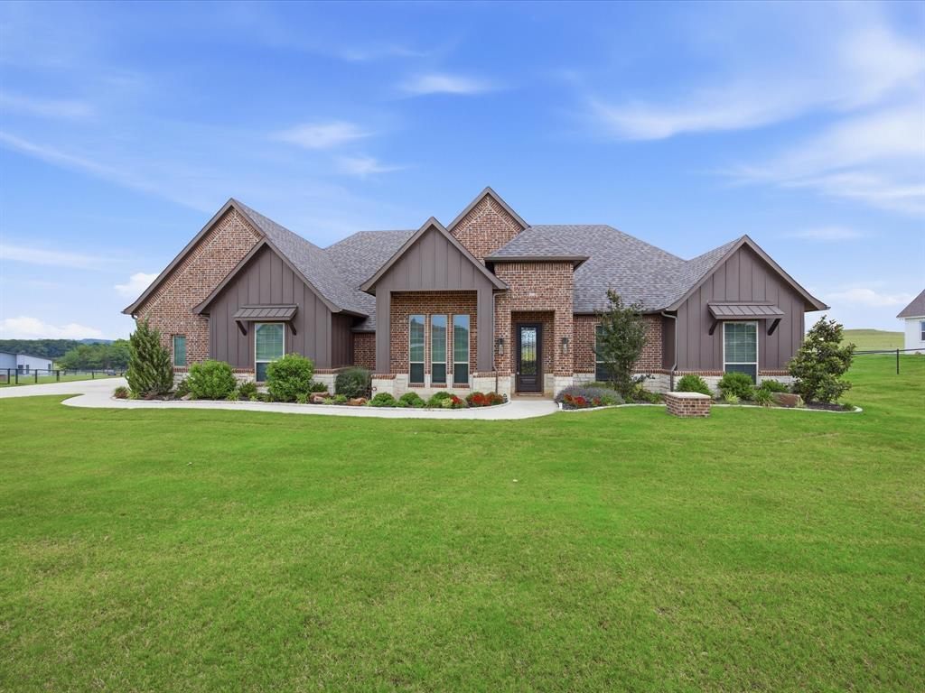 Welcome to this stunning 4-bedroom, 2.5-bath brick and stone home nestled on 2 beautiful acres in the highly sought-after Quail Ridge Estates. Designed with both comfort and entertaining in mind, this spacious home offers an open-concept living, kitchen, and dining area perfect for hosting guests or enjoying quality time with family. The oversized living room features an electric fireplace with a gorgeous brick and stone hearth, ceiling fan, and an abundance of windows that fill the space with natural light. The chef’s kitchen is a dream with a massive 5x9 island, granite countertops, stainless steel appliances, double ovens, electric cooktop, and a large walk-in pantry. The split floor plan provides privacy, with the primary suite serving as a phenomenal retreat. Enjoy a spa-like en suite complete with separate vanities, a generous walk-in shower, soaking tub, and an enormous walk-in closet. An office with a walk-in closet offers flexibility for working from home or additional storage. On the opposite side of the home, three spacious bedrooms share a well-appointed bathroom featuring dual sinks, built-in cabinetry, and a tub and shower combo. The laundry room is thoughtfully designed with built-in cabinets, granite counters, and space for a full-size washer and dryer. Step outside to enjoy the covered back porch overlooking peaceful views and a beautifully maintained, fenced and cross-fenced backyard with pipe and no-climb fencing. Additional features include a saltwater softener system, irrigation system, three-car garage, whole house generator plug. Beautifully landscaped and loaded with upgrades, this property offers the perfect blend of luxury, functionality, and country tranquility. Come see this incredible home today!