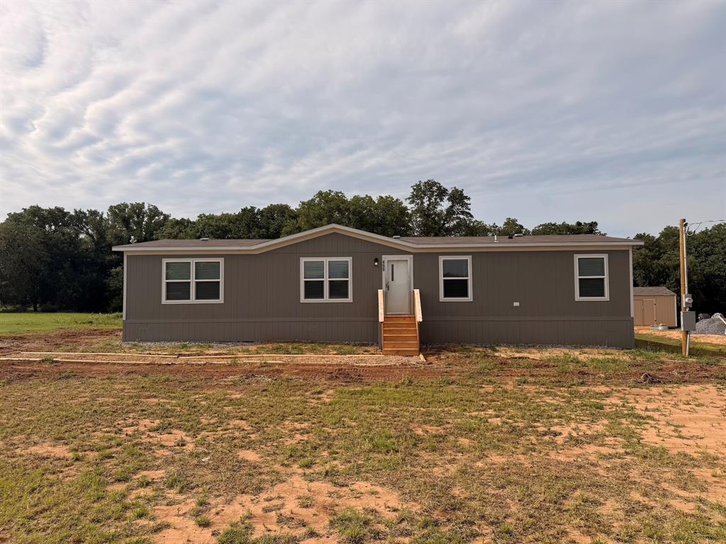 Experience peaceful country living in this brand-new 4-bedroom, 2-bath home situated on nearly half an acre. Designed for comfort and functionality, the home features an open-concept layout with recessed lighting and a modern kitchen showcasing a custom backsplash, island, and included appliances—refrigerator, range, and dishwasher. The spacious living room easily accommodates large furniture, while the dining area and den sit conveniently next to the kitchen. A generously sized utility room offers plenty of space for a full-capacity washer and dryer. The primary suite includes a walk-in closet and private ensuite bathroom. Additional bedrooms provide ample space for family members, guests, or even a home office. Step outside to enjoy the 8x10 back deck, perfect for relaxing or hosting gatherings. Additional highlights include a private well, private septic system, no HOA, and a one-year manufacturer’s warranty. Schedule your showing today and don’t miss this opportunity!