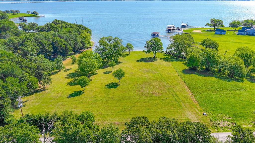 Experience the perfect blend of space, privacy, and waterfront living on this beautiful 2-acre homesite in Moonlight Point on Richland Chambers Lake. With a scenic stretch of shoreline and wide-open views, this property offers an incredible setting to build your dream home. The land features a gentle slope toward the water, scattered mature trees, and plenty of usable space to design a layout that fits your vision. A 315-foot retaining wall, completed in 2023, enhances the shoreline and makes this property ready for your future lakefront plans. With approximately 300 feet of shoreline, this lot is ready for a boat dock, giving you the ability to fully enjoy life on the water. Positioned in a protected cove with easy access to open water, this property offers both calm surroundings and quick access for boating and recreation. The lot is located on a paved road with electric and water available, adding convenience to your build process. Located in a well-maintained lakeside community, Moonlight Point offers a cohesive, custom-built feel that helps preserve the overall aesthetic and long-term value of the neighborhood. Just 20 minutes from Corsicana for dining, shopping, and everyday essentials, and about an hour south of Dallas, this property offers the perfect balance of peaceful lake living and accessibility. Enjoy direct access to Richland Chambers Lake, known for boating, fishing, and year-round recreation. Whether you are looking for a full-time residence or a weekend getaway, this property offers the setting, space, and views to bring your plans to life.