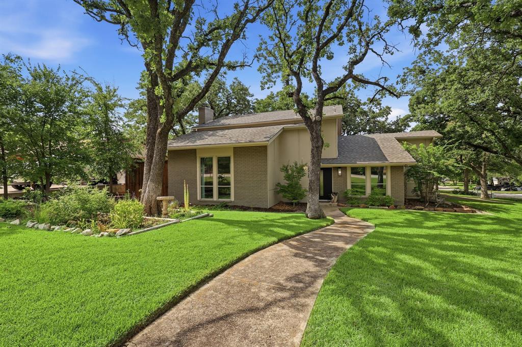 Tucked beneath towering trees on nearly a third of an acre, this fully renovated 4 bedroom, 3.5 bath home offers the perfect blend of timeless charm and modern comfort.  Designed with today's lifestyle in mind, the open-concept floor plan is filled with natural light and enhanced by wide-plank luxury vinyl flooring and beautifully updated finishes.  The heart of the home is the upgraded kitchen featuring crisp white cabinetry, quartz countertops, a massive center island, gas range, walk-in pantry, and a separate appliance closet for added organization. The kitchen flows seamlessly into the impressive living area with soaring ceilings and a stunning gas fireplace that creates a sophisticated focal point for entertaining.  The downstairs bedroom with ensuite bath offers the perfect guest retreat, multigenerational living space, or home office. Upstairs, the spacious primary suite provides a relaxing escape with a luxurious private bath and large walk-in closet.  Step outside to enjoy the expansive backyard shaded by mature trees, where you'll find a patio, raised garden planters, a storage shed, and plenty of room to add a pool—offering endless possibilities for outdoor living. The side-entry garage on Lake Vista provides parking flexibility.  With convenient access to I-35 E, this gorgeous home offers an easy commute while being just minutes from Lake Lewisville. You'll also appreciate being close to Doubletree Ranch Park for outdoor recreation, all while feeding to sought-after McAuliffe Elementary School. With its extensive renovations, generous lot, and exceptional location, this move-in-ready home is one you won't want to miss.