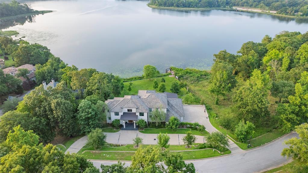 Situated on a sprawling waterfront lot, this Cascades estate offers the perfect blend of luxury, privacy, and modern design. As you step inside, you'll be greeted by soaring 20-foot ceilings, creating an open and airy atmosphere. The picturesque views of the lake and surrounding nature will leave you in awe, creating a serene and tranquil environment. The main floor encompasses the open living room, dining room, gourmet kitchen, 2 offices, a mudroom and bedroom suite. Prepare to be amazed by the stunning glass doors that seamlessly disappear, effortlessly blending indoor and outdoor living spaces. The kitchen is a culinary masterpiece, clad in flawless soapstone, creating a sleek and elegant aesthetic. Every detail has been meticulously thought out, from the custom cabinetry to the top-of-the-line appliances. Whether you're a professional chef or a cooking enthusiast, this kitchen will exceed your every expectation. This estate offers exquisite spaces that are both delightful and entertaining. The flex space upstairs is perfect for a billiard room or a versatile entertaining space. The primary bedroom suite is a retreat in itself, with its own private balcony overlooking the lake. Begin and end your day in this tranquil space, enjoying the peaceful ambiance. Additionally upstairs, there are 2 more large bedrooms with en suite bathrooms and large closets-both with extraordinary views. Step outside to the impressive poolside retreat, with an outdoor kitchen and half bath. Fully embrace the beauty and tranquility of lakeside living. Take advantage of the boat dock and spend your days boating or simply basking in the sun. This cutting-edge Cascades estate offers a rare opportunity to own a truly remarkable property. With its modern design, stunning features, and unparalleled surroundings, this home is a haven for those seeking the perfect blend of luxury, privacy, and natural beauty.