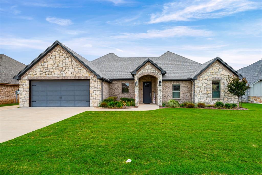 Beautifully maintained 4-bedroom, 2-bath home in the newest area of Pecan Plantation with exceptional curb appeal and thoughtful upgrades throughout. Upgraded stone and brick exterior, mature landscaping, and a peaceful lot create a warm and inviting first impression. Spacious open floorplan features a large living room with fireplace and a bright open kitchen with granite countertops, custom cabinetry, abundant storage, breakfast bar seating, and new stainless steel appliances. Refrigerator, washer, and dryer all convey, making this home truly move-in ready. Designer colors and ceiling fans throughout add warmth and comfort. Home also features hardwired internet connections throughout with centralized network wiring and a OneHome smart home system for seamless connectivity and modern convenience. Covered back porch overlooks the landscaped backyard and offers the perfect space to relax or entertain. Oversized 2-car garage includes EV wiring, side entry door, built-in storage racks, plus additional golf cart garage or storage area with separate driveway access. Conveniently located near the front gate for easy access to Historic Granbury Square, shopping, dining, golf, and community amenities. A must-see home loaded with upgrades buyers will love.