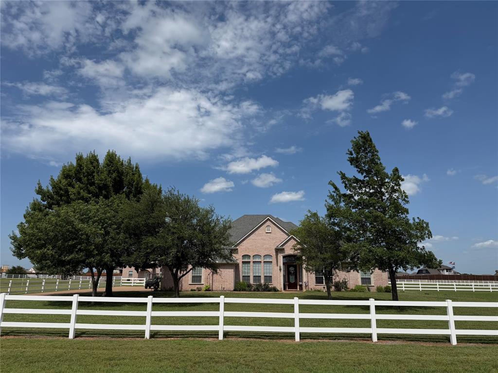 Nestled on 3.73 acres just 5 minutes from the Historic Granbury Square. This stunning 3-bed, 2-bath, 3-car garage custom brick home offers the perfect blend of refined interior living & exceptional outdoor functionality—all with NO HOA. Step inside & be greeted by soaring ten-foot ceilings, crown molding, decorative lighting, & a warm gas fireplace that anchors the open living space. The spacious kitchen features a gas cooktop (2021), built-in cabinetry, a walk-in pantry, & a breakfast bar, making it ideal for everyday living & entertaining. The primary suite is a true retreat, complete with a garden tub, separate shower, dual vanities, and a custom closet system. Updates & Improvements Include: Puronics Water Filter & Softener System (2021), On-demand tankless gas water heater (2021), Replaced AC plenums on Trane AC (2021) Ac has transferable warranty good thru (2028), White vinyl backyard fence & full 3-rail white vinyl perimeter fence (2021), Window shutters in living area (2022), New water well pump (2024), Aerobic septic sprinkler pump replaced (2026), House roof replaced (2020), Gutters replaced (2023), Shop roof replaced (2023). Step outside & enjoy the covered patio, with outdoor kitchen, perfect for relaxing & entertaining on Texas evenings. The property has impressive 35x40 detached shop with an office that includes a bathroom with a walk-in shower. Shop also has four 10 ft high bay doors, offers covered parking for RV or boat. The property has covered parking for up to 7 vehicles. This is a beautifully maintained home designed for comfortable living. You don't want to miss out on this one. Call TODAY to schedule your private showing!