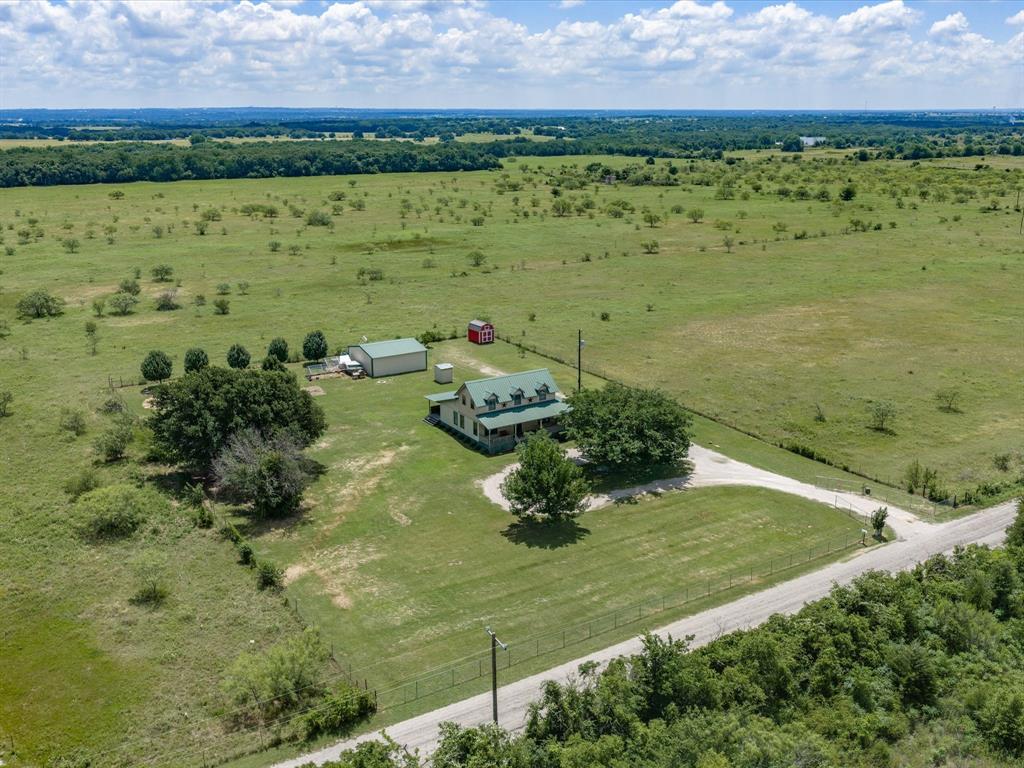 Welcome home to the peaceful charm of country living in Chico, Texas! Nestled on approximately 1.5 acres, this inviting farmhouse offers the perfect blend of comfort, functionality, and the simple joys of rural life. Inside, you’ll find 3 bedrooms and 2 bathrooms, with a warm and welcoming living, dining, and kitchen area designed for gathering around the table, sharing meals, and making memories with family and friends. Just off the dining room is a versatile flex space that can easily serve as a home office, second living area, playroom, homeschool space, or whatever best fits your lifestyle. The primary suite is conveniently located downstairs and features a walk-in closet, while upstairs you’ll find two additional bedrooms sharing a full bathroom with dual sinks. Ceiling fans throughout the home and hard-surface flooring make everyday living comfortable and easy to maintain. Step outside and enjoy the beauty of country mornings from the large front porch or unwind in the evenings on the spacious back porch. Whether you’re sipping coffee in the shade during the summer or wrapped in a cozy blanket on a cool Texas evening, these outdoor spaces are sure to become your favorite retreat. The property also features a 30x30 shop, storage building, in-ground storm shelter, full fencing, and an electric gated entrance, providing both convenience and peace of mind. If you’ve been dreaming of a quieter pace of life with room to grow a garden, raise your own food, and enjoy the freedom of country living, this charming farmhouse is a must-see. Schedule your showing today and discover all the possibilities waiting for you in Chico!