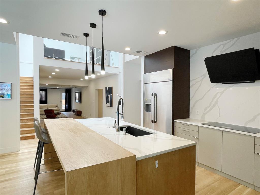 Discover this modern masterpiece tucked within an exclusive enclave of only eight homes, nestled on a quiet cul-de-sac in the heart of Dallas. Designed for both beauty and lifestyle, this one-of-a-kind residence boasts panoramic views framed by endless floor-to-ceiling windows, filling every corner with natural light. Enjoy resort-style outdoor living with an oversized pool, outdoor kitchen, towering mature trees, and a lush bamboo-covered privacy wall—still leaving abundant space for grand gatherings and entertaining. Beyond the pool, a gated extension of the property offers additional land shaded by mature trees, creating a private park-like retreat right in your own backyard. Inside, the chef’s kitchen shines with professional-grade luxury appliances, a built-in refrigerator, wine cooler, and an expansive quartz island. The open and airy floor plan flows seamlessly, featuring 5 bedrooms, 5.5 baths, 4 expansive living areas, a fitness room, and a 3-car garage. The owner’s retreat is a must-see, offering a private sanctuary of elegance and comfort. Upstairs, a striking mezzanine overlooks the living areas, leading to an en-suite bedroom and bath—perfect for guests or extended family. All windows replaced, $45K total.This home is truly the definition of modern luxury living, combining privacy, sophistication, and lifestyle in a premier Dallas location.
