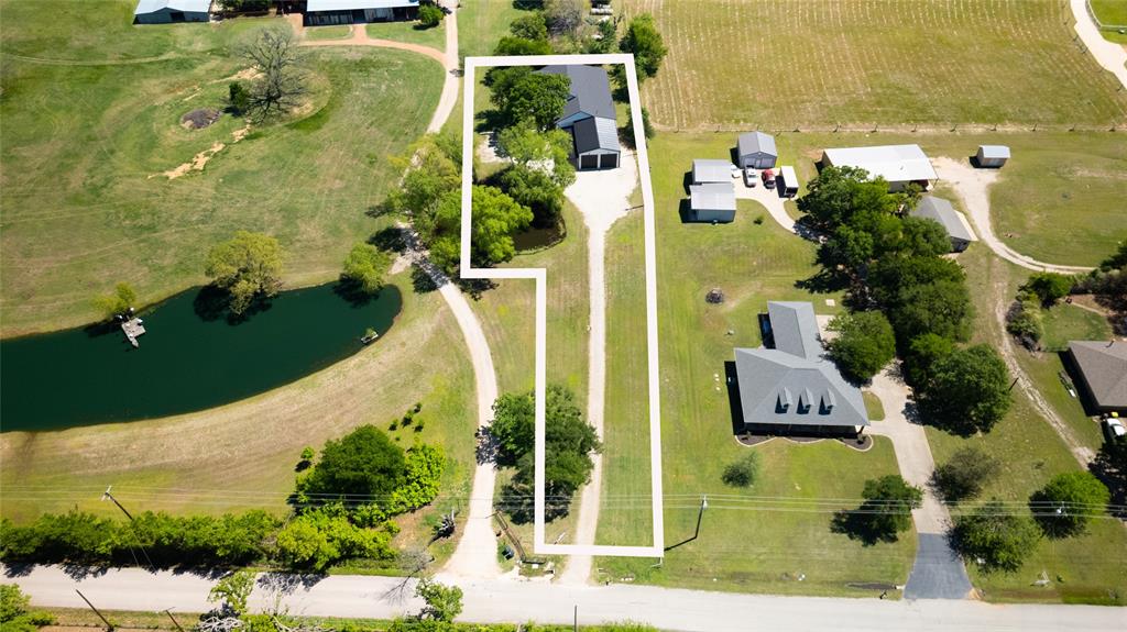 Farmhouse Living with Pond Views & Massive Shop — Rare Find!
Welcome to a truly special property where thoughtful design, custom features & peaceful country living come together to create a place that just feels like home. Situated on approximately one acre with no HOA, this custom home offers privacy, flexibility & functional spaces designed for everyday living & entertaining.
Inside, the home features 4 spacious bedrooms, 3 full bathrooms & an office with vaulted ceilings, creating an inspiring space for working from home! Tall ceilings, abundant natural light & an open layout provide a warm & welcoming feel, while upgraded finishes & plentiful storage throughout add comfort & convenience.
A standout feature of the home is the presence of 2 bedrooms with private en suite baths, offering flexibility for guests or multi-generational living. The thoughtful layout allows for both connection & privacy, creating spaces that comfortably adapt to changing needs.

Outdoor living & functionality truly set this property apart. Expansive covered patio areas provide the perfect place for entertaining or relaxing, while a versatile bonus room located just off the back porch offers additional space for hobbies, workouts or games!

The property also features a huge insulated shop with multiple overhead doors, second-story storage space & room for equipment, projects or recreational vehicles. RV hookups, designated lawn mower parking & a dedicated gardening area add to the overall usability of the property.
Homes offering this level of space, storage, workshop functionality & outdoor living are increasingly difficult to find in Aubrey. With its combination of custom features, flexibility & exceptional value, this property presents a rare opportunity for buyers ready to take advantage of a competitively positioned home in today's market.

Schedule your private showing today & experience firsthand the space, versatility & lifestyle this one-of-a-kind property has to offer.