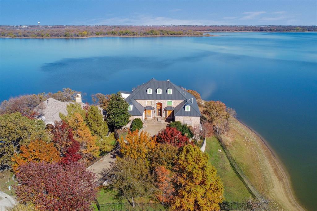 This exquisite home is beautifully situated on the shores of Lake Lewisville, offering panoramic views that will take your breath away from every corner! The property has been completely gutted down to the studs, providing a blank canvas for its new owner to design and customize to their heart's desire. As you step inside, you're welcomed into a vast living space that seamlessly flows into the kitchen and dining areas, creating an ideal setting for entertaining and family gatherings. Envision crafting your own luxurious chef’s kitchen, tailored precisely to meet your culinary passions! The main floor boasts two inviting bedrooms, one of which features elegant custom millwork that includes a built-in bed, matching nightstands, and abundant storage solutions, perfect for maximizing space and style. The primary retreat is truly exceptional, designed to be a personal sanctuary. It offers ample room for spacious his-and-her bathrooms, expansive closets, and a comfortable seating area, all with direct access to the balcony that overlooks the lake, allowing for peaceful mornings and serene evenings. Venturing upstairs, you'll discover four additional bedrooms, each adorned with meticulously crafted millwork closets, providing both functionality and flair. On the lower level, you’ll find an oasis of relaxation with an indoor pool and spa that invite year-round enjoyment. This space also includes another generous living room and a versatile bonus exercise room—perfect for staying fit without leaving the comfort of home. A conveniently located full bathroom enhances accessibility for guests and residents alike. For added peace of mind, the roof has been recently replaced with a contemporary black metal roof, combining style with durability, ensuring that this home remains a cherished retreat for years to come.
