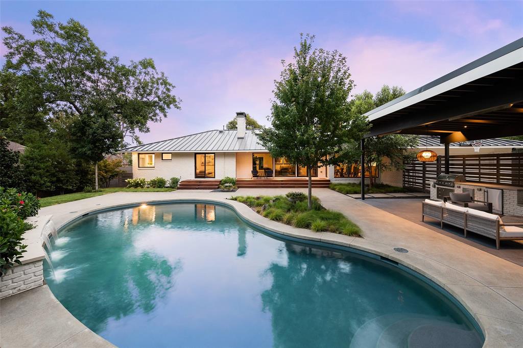 Boasting sleek design features and smart-home technology, this midcentury modern home sets the new standard in tech-savvy living. The 4,519-square-foot residence — sited on a 0.4-acre lot in North Dallas’ scenic Janmar Estates— comprises 5 bedrooms, 4 full baths & 2 half baths. The 1st-floor primary suite includes a cast stone FP, 2 walk-in closets & an en suite bath with an air jetted tub & thermostatic shower— all opening out onto the stunning backyard & pool area. Ideal for outdoor entertaining, the shady veranda is outfitted with an outdoor kitchen, FP & outdoor heaters. Two additional bedrooms with en suite baths, along with a half bath, a utility room & an attached 2-car garage, round out the home’s first floor. Upstairs, you’ll find two bedrooms adjoined by a true Jack and Jill bathroom as well as a spacious game room and a powder bath. This move-in ready contemporary gem has been thoughtfully renovated and reimagined, incorporating the best in modern-day technology and design.