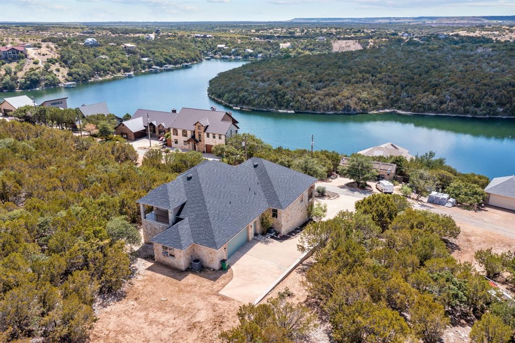 Welcome to your dream Hill Country retreat. This FULLY FURNISHED stunning property offers a perfect blend of modern living and natural beauty, making it an ideal escape to beautiful Possum Kingdom Lake. Nestled in a serene setting, the lake views and natural rolling hill country landscape is the perfect combination. This home boasts an open concept design that creates an inviting atmosphere for both residents and guests, you will never not have enough space. Generous sized bedrooms, two living spaces, circle driveway, short distance to marina and more! This is a must see. The Cliffs resort also offers 24hr security, sports complex, playground, championship golf course, restaurant, spa, marina and MORE.