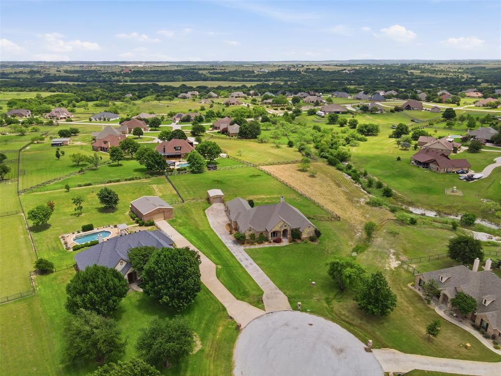 Welcome to your own slice of open country living in the highly sought-after Mustang Creek Subdivision! This stunning one-owner home sits on a huge lot that delivers the kind of space and freedom most homeowners only dream about. With four spacious bedrooms and three and a half bathrooms, there is room for everyone to spread out and breathe easy. Step inside and you will immediately notice the open floor plan and tall ceilings that create an airy, light-filled atmosphere throughout the home. The layout flows effortlessly from room to room, making it ideal for both everyday living and entertaining guests who never want to leave — and honestly, who could blame them? The primary bedroom offers a true retreat, while three additional bedrooms provide plenty of flexibility for family, guests, or a home office. Every corner of this home reflects the pride of single ownership and thoughtful care. Outside is where things get really exciting. The property features an awesome detached bricked workshop that is perfect for hobbyists, craftsmen, or anyone who needs serious workspace. A water well adds both practicality and value, complementing the expansive lot beautifully. The rural feel is undeniable, yet you are only about five minutes from Chisholm Trail, keeping shopping, dining, and entertainment wonderfully close. This is a rare opportunity to own a property that perfectly balances peaceful country charm with everyday convenience in one of Benbrook's finest communities. Schedule your private showing today before this gem finds its forever family!