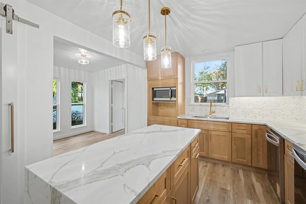 Stunning, fully remodeled modern luxury home in the highly coveted Lovers Lane Heights area! This 1948 classic has been completely reimagined by Signature Development Co. from a 3 Bedroom, 2 Bath spanning to a 4 Bedroom, 3 Bath. The main residence consists of 4 spacious bedrooms and 3 full spa inspired baths, with brand-new upgraded systems, designer finishes, and sweeping natural light. The chef’s kitchen boasts custom cabinetry, premium stainless appliances, and an exquisite quartz waterfall island that flows seamlessly into the open-concept living space. Step into your private backyard oasis to find a rare, oversized detached 2-car garage complete with a fully finished separate bonus room and half bath—the ultimate setup for a private home office, fitness studio, or guest house. Added bonuses are the full size laundry room, breakfast nook, and walk-in pantry. Additionally, the seller is offering financing incentives and a buyer credit for custom built-ins from Closets by Design to customize your walk-in pantry, master closets, and mudroom. Unbeatable location minutes from Love Field, top-tier dining, and high-end shopping!