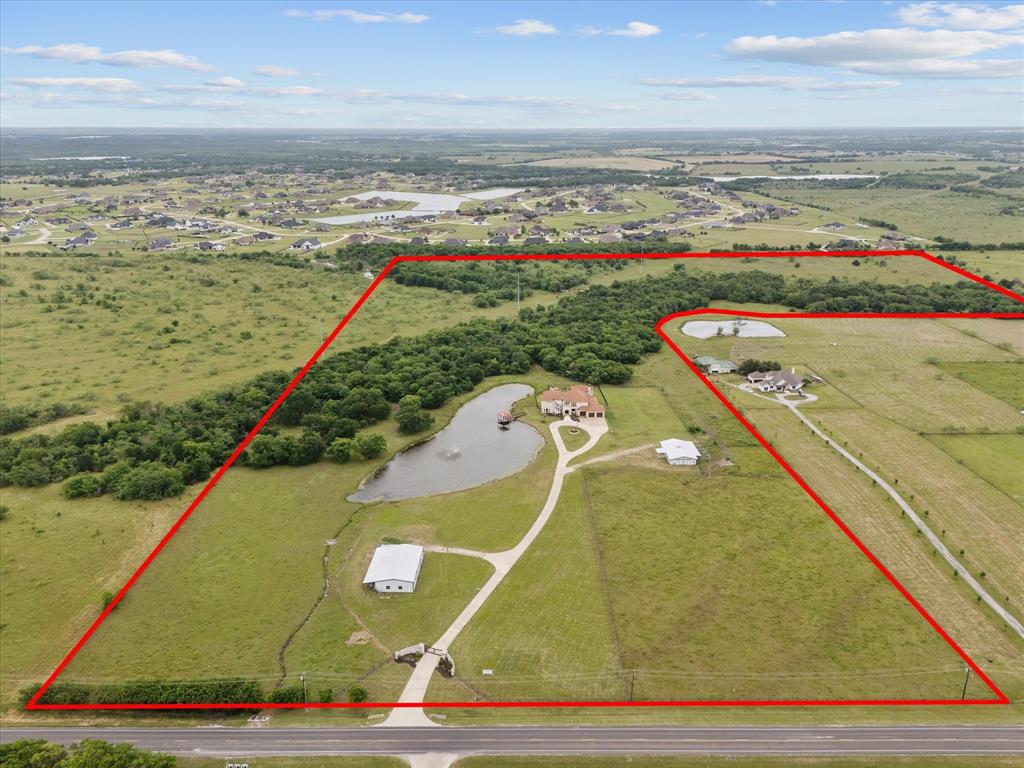 Bring the Longhorns, Bring the horses!
Welcome to Fisherman's Lake Ranch!
Set on 64 fully fenced acres just 30 min from Dallas, this private gated ranch offers a rare balance of seclusion and accessibility. A large, stocked fishing lake with covered gazebo, along with two stock tanks provides beauty and function for livestock and recreation.
Equestrian facilities are thoughtfully designed with a six-stall fully equipped barn, wash bay, tack room, bathroom and an office. Separate event center and bunkhouse living quarters with 3 bedrooms, a full kitchen and an expansive game area, Ideal for extended guest quarters.   This could be a venue for so many uses, including parties, conference center, meeting Western Weddings, and with this fully equip kitchen you can feed hundreds.
The land is rich with quail, native wildlife, deer and more, creating a true Texas experience.
900-ft. concrete drive leads to the impressive main residence offering refined craftsmanship that set the tone.  Walls for trophies plus that longhorn rack. Built for comfort and entertaining, soaring ceilings, rich burl wood, a grand fireplace, and large chefs' kitchen for gathering. Baths offer quartz, counters and each bedroom have a private bath. Elevator for those who desire total luxury.  The main bedroom has a fireplace and two double doors opening to your private balcony where you can overlook this estate. Game room sports a wet bar, room for a pool table, a safe room and wall of build ins. Oversized office sports 2 individual desk areas and wall of bookcases. This area overlooks an oversize pool.

Outdoor living is exceptional with one of the largest entertain areas in the region. Enjoy a resort style pool with swim up bar, tanning ledge water features and expansive covered patios for year-round entertaining fireplace, full kitchen area for outdoor living.
This remarkable 64-acre ranch captures the essence of Texas living, with the added benefit of future development.