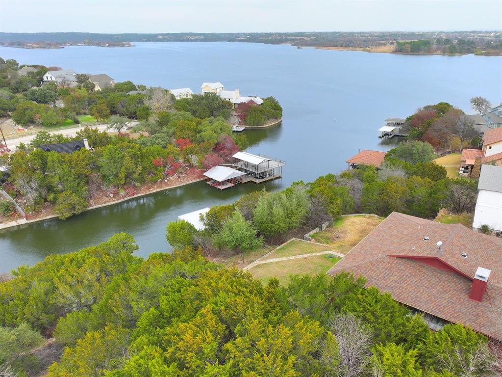 Fabulous Lakefront Living with Panoramic Views! Welcome to this exceptional waterfront retreat, offering breathtaking vistas that stretch for miles across the lake. Watch the city of Granbury fireworks from the deck! Located in the gated Canyon Creek community with a full-time security gate, this property sits on a private, half-acre lot, fully enclosed with its own private gate for maximum privacy. 

Step inside to discover a thoughtfully designed home featuring 3 spacious bedrooms, 2.5 bathrooms, and a stunning open-concept kitchen that flows seamlessly into the dining and living areas. Enjoy the warmth of a double-sided fireplace connecting the cozy family room and a dedicated office—perfect for both relaxation and productivity. The home boasts multiple skylights that bring in tons of natural light! 

The primary suite boasts two large closets, flexible space for a sitting area or dressing room, and a luxurious, fully remodeled en-suite bath with a deep soaking tub, separate shower, and dual vanities. 
Just off the dining area leads to a covered porch, the ideal spot for savoring your morning coffee or taking in spectacular evening sunsets over the water. 

Downstairs, you'll find two additional bedrooms, a full bath, and a secure storm shelter or safe room for peace of mind. Step out onto the expansive covered porch, where an oversized enclosed storage area with a sink awaits—easily convertible into a second kitchen for outdoor entertaining and grilling. New roof in 2023.

Venture down to the water’s edge to enjoy a protected natural inlet, perfect for swimming, fishing, and a variety of lakeside activities. This home offers the ultimate lake lifestyle, with ample space and modern comforts for year-round living or weekend getaways. Don’t miss this rare opportunity to own a true lakeside sanctuary!