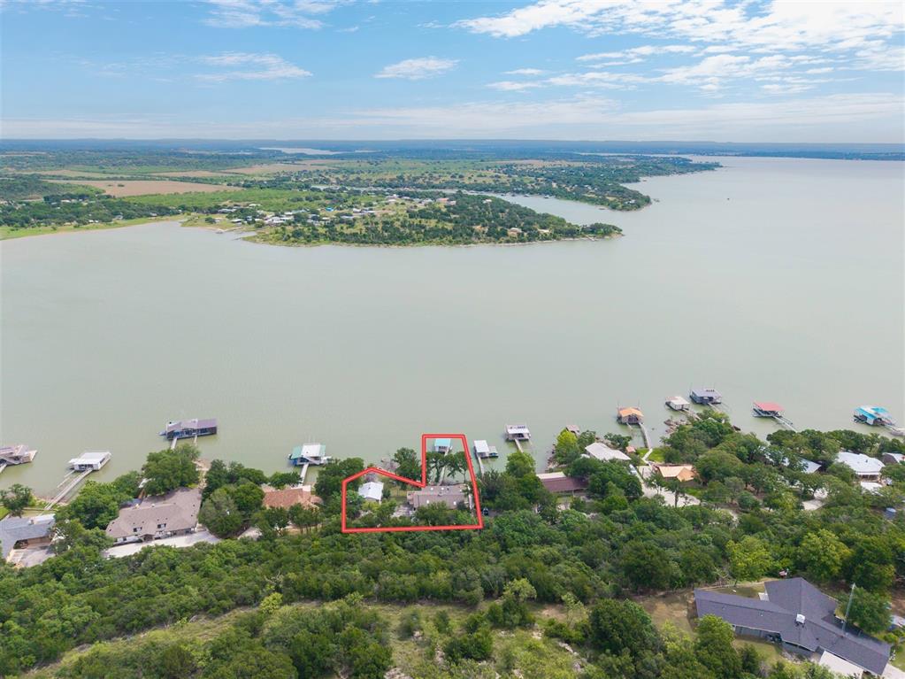 Just in time for Summer to enjoy this charming Lake Brownwood water-front home and dock. Plenty of room for guests in this 3-bedroom 3-bathroom home on two water-front lots. The kitchen has an open concept feel about it with easy access to the dining area and living room. The living room has a fire place and plenty of large windows to enjoy the views of the lake. The primary bedroom and bathroom along with a guest room are located on the first level and the third bedroom with full bath is located on the lower level. The lower level has access to the back porch and beautiful water-front views. The back yard has trees garden areas with beautiful landscaping and plenty of elbow room. From the back yard you can enter lake Brownwood thru the gate and ease down to the water on the rock steps. You will enjoy the boat dock with its storage area and boat slip and good deep water. This property is close to the Hideout and gold resort with easy access into Brownwood.