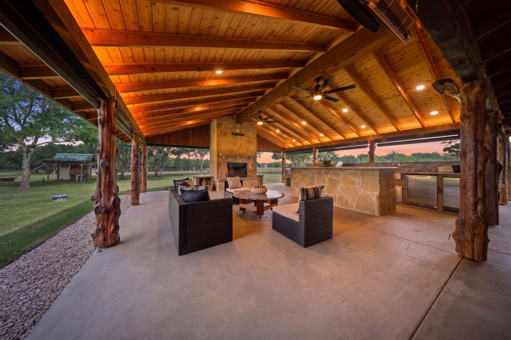 Some homes check boxes, This one transforms how you live! Welcome to Green Acres—where the simple act of coming home becomes a reset, and the noise of the outside world slips quietly out of reach. Discover this stunning property with Gated Entrance on 5 fenced acres! This estate offers rare privacy backing up to Lake Ray Roberts Corps of Engineers land. Designed for both refined living & outdoor enjoyment. Residence showcases rich wood interiors, WB fireplace,& wraparound porch capturing serene, wooded views. The outdoor living experience is truly elevated, featuring fully equipped covered kitchen with granite countertops, ice maker, sink, mini fridge, grill, griddle,& sitting area perfect for entertaining year-round! 2 overhead propane heaters, ceiling fans, electric shades,& fireplace create comfortable setting every season. Property comes with private well,storm cellar, generator hookup,& covered RV storage. The 40x60 detached 4-stall shop-barn offers exceptional versatility, complete with storage & office-man cave,bath, cedar closet. Located just 8.4 miles from DNT extension & in PPISD. Ideal for lake lovers, outdoor enthusiasts, & those seeking private country living! please transaction desk for a full list of upgrades and updates