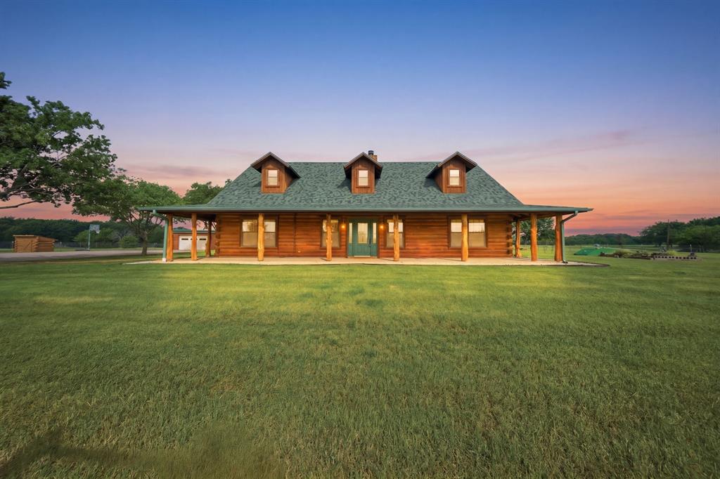 Some homes check boxes, This one transforms how you live! Welcome to Green Acres—where the simple act of coming home becomes a reset, and the noise of the outside world slips quietly out of reach. Discover this stunning property with Gated Entrance on 5 fenced acres! This estate offers rare privacy backing up to Lake Ray Roberts Corps of Engineers land. Designed for both refined living & outdoor enjoyment. Residence showcases rich wood interiors, WB fireplace,& wraparound porch capturing serene, wooded views. The outdoor living experience is truly elevated, featuring fully equipped covered kitchen with granite countertops, ice maker, sink, mini fridge, grill, griddle,& sitting area perfect for entertaining year-round! 2 overhead propane heaters, ceiling fans, electric shades,& fireplace create comfortable setting every season. Property comes with private well,storm cellar, generator hookup,& covered RV storage. The 40x60 detached 4-stall shop-barn offers exceptional versatility, complete with storage & office-man cave,bath, cedar closet. Located just 8.4 miles from DNT extension & in PPISD. Ideal for lake lovers, outdoor enthusiasts, & those seeking private country living! please transaction desk for a full list of upgrades and updates