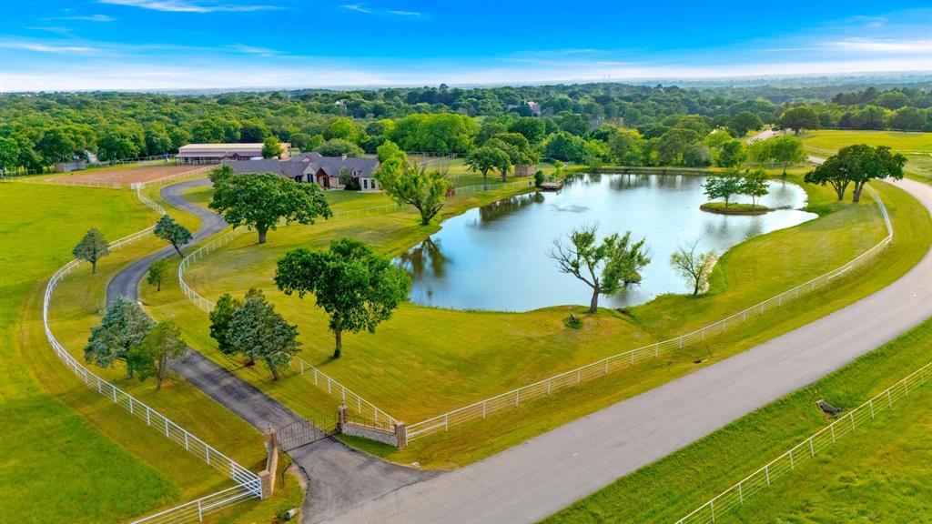 Set on approximately 14.5 acres in the heart of North Texas horse country, this gated estate offers a well-rounded combination of a spacious residence, equestrian improvements, and a location that keeps you connected to the broader DFW area. Positioned just minutes from Denton with convenient access to major thoroughfares, the property provides a rural setting without sacrificing proximity to shopping, dining, healthcare, and both DFW International and Dallas Love Field airports.  The residence offers approximately 4,400+ square feet of thoughtfully designed living space, up to five bedrooms, featuring a split-bedroom layout that balances privacy and separation. Multiple living and dining areas offer flexibility for a range of uses. The kitchen is equipped with double ovens, gas cooking, and ample workspace, while the private primary suite includes a sitting area and an adjoining office. An upstairs bonus suite adds additional flexibility for guests, extended family, or a variety of personal uses. Additional features such as a pool, outdoor living areas, and a generator contribute to its overall functionality and comfort.  Outdoors, the land is defined by mature trees, pasture, and a private pond supported by a private water well, creating a natural backdrop that enhances the scenic acreage setting. The sandy loam soil, highly regarded for equestrian use, makes the property especially appealing for horse enthusiasts.  Equestrian improvements include a well-designed insulated barn with up to 12 stalls, tack and feed areas, wash rack, and a flex-room with kitchenette and full bath, along with fenced pastures and supporting infrastructure.  With its combination of a luxury home, usable acreage, equestrian amenities, and a convenient location near Denton and the surrounding DFW conveniences, 7583 Mountain View presents a well-balanced opportunity in one of the area’s most desirable acreage settings.