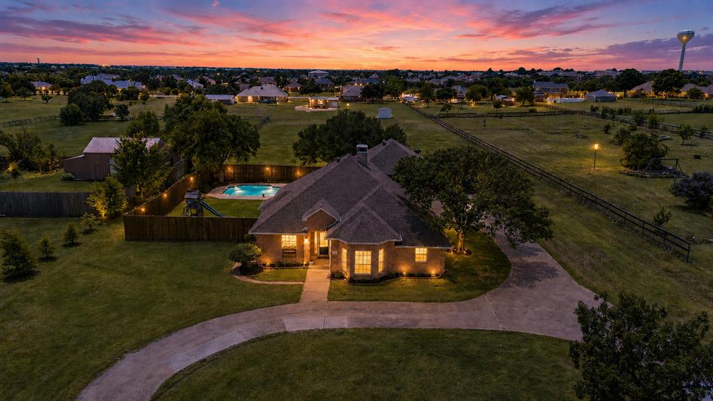 Rare opportunity to own a beautifully updated and meticulously maintained home on 1.9 acres in highly sought-after Wylie ISD with NO HOA! Offering 4 bedrooms, 3 full bathrooms, and a flexible floor plan, this property combines the space and privacy of country living with the convenience of being just minutes from downtown Wylie, local dining, shopping, and easy access to Parker Rd and 1378 Country Club. Step inside to find soaring 10-foot ceilings, crown molding, abundant natural light, and a spacious living room anchored by a cozy fireplace and custom built-ins. The fully renovated kitchen was completed in 2023 and features quartz countertops, updated appliances, double ovens, ample cabinetry, generous counter space, and beautiful views of the backyard through a wall of windows spanning the rear of the home. The oversized primary suite offers double vanities, a garden tub, separate walk-in shower, and plenty of space to unwind. Two additional bedrooms and a full bathroom are located downstairs. Upstairs, you'll find a spacious fourth bedroom with a closet and private bathroom, making it ideal as a guest suite, game room, office, media room, or second living area. This versatile space also offers private access to the walk-out balcony, where you can enjoy sweeping views of the pool and acreage below. Designed for entertaining, the backyard features a large covered patio, sparkling pool and spa, and outdoor bar area that could easily become an outdoor kitchen. Beyond the fenced backyard, enjoy an additional acre of land with endless possibilities for a shop, garden, barn, or recreational space. A circle drive and oversized parking area provide plenty of room for guests, while the two-car garage provides extra storage. Refrigerator, washer, and dryer will convey with an acceptable offer. Acreage properties in Wylie with NO HOA are hard to find. Don't miss this move-in ready home with room to entertain and enjoy country living with city convenience!