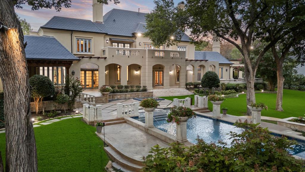 Price Improvement! Experience refined living in an 8,300+ -square-foot timeless, French château–inspired estate, perfectly positioned along the fairway in one of the area’s most exclusive 24-7 gated and guarded communities. Blending old-world elegance with modern luxury, this residence features five spacious bedrooms, each with an ensuite bathroom and walk-in closet, providing privacy and comfort for family and guests alike.
Inside, soaring cathedral ceilings with carved wood beams, oversized windows and abundant natural light create a grand yet inviting atmosphere. The primary suite is a serene retreat with dual over sized closets, dual vanities, fireplace, terrace, a private exercise room, and breathtaking views of the manicured grounds. A private guest suite with exterior access ensures comfort and privacy for visitors.
Designed for elevated living and entertaining, the home features a gourmet kitchen, multiple elegant terraces, a balcony overlooking the lush landscape, and an expansive outdoor area featuring a new kitchen with bbq grill, sink, pergola, infinity-edge pool, spa, and sunken fire pit. A dedicated theater room offers the ultimate cinematic experience adjacent to a game room with fireplace and bar.
Recent updates, including a new roof, complement the property’s enduring architecture. The four-car garage motor court provides convenience, while the location offers award-winning schools and quick access to both DFW and Love Field airports, as well as fine dining, shopping and health care.
This exceptional estate delivers timeless design, luxurious amenities, and an unmatched fairway setting - one of the iconic homes in The Estates at Tour 18.