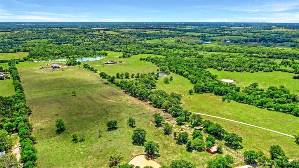 Picturesque Ranch with rolling terrain and panoramic views of the countryside. Mature trees throughout the property. The hilltop has a large Barndominium with shop and storage for Toys and UTV ATV. Stocked lake and 3 ponds on the property. The frontage is pipe and cable fences, pipe corrals, equipment shed with enclosed storage on one end.  Large covered porch and outdoor fire pit with seating. Deer and other wildlife are in the area. The property adjoins a larger ranch on three sides. Nice homes on acreages are in the area. Quiet location for weekends or a great place to live. The Barndo has three bedrooms, two and one half baths. Gourmet kitchen with large island. Appliances included. Multiple open living or dining areas with another living area on the second floor. Primary bedroom is downstairs. Most of the furnishings and fixtures are included with the sale. Move in ready!  Cattle and equipment are available on private treaty. Call for appointment , don't miss this one.