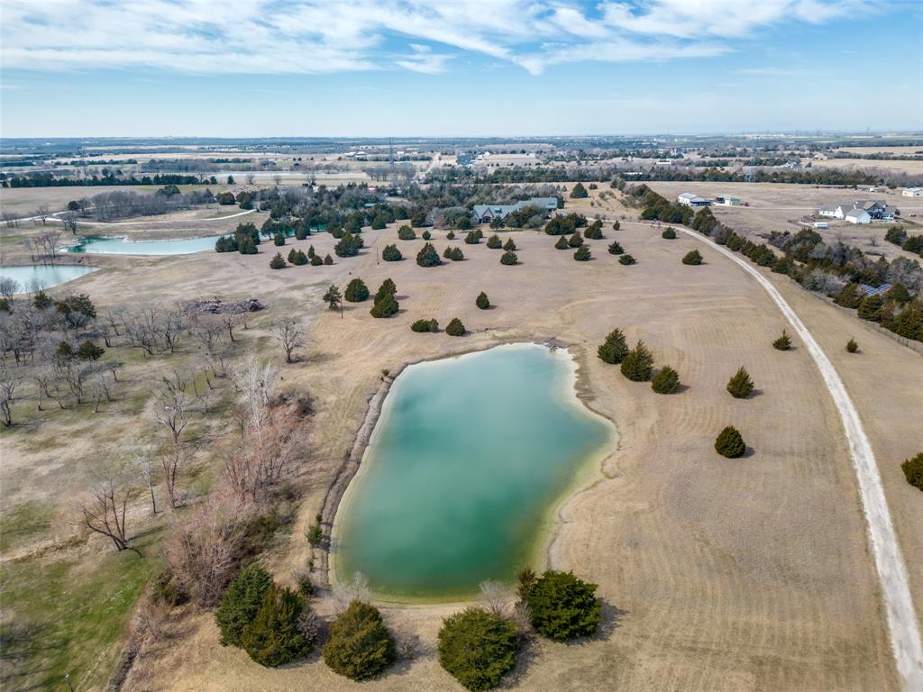 Amazing estate on almost THIRTY ACRES in Celina including over 9200 square foot home that has an updated interior that is worthy of a magazine shoot.  6 Bedrooms, 5 Full Baths, and 2 Half Baths in this sprawling floorplan.  Mother in Law or Guest Quarters can be accessed from the main house, or could be separated.  Main home kitchen is exquisite in every way.  Commercial grade Thermador appliances including built in refrigerator, wine fridge, and range with double ovens, 6 gas burners, griddle and grill.  50 square feet of island space is a chef’s dream.  Family room boasts floor to ceiling stacked stone fireplace and 20 feet of elevation.  Primary retreat is awe inspiring with gorgeous built ins.  Primary bath features amazing free standing tub, two person shower with dual heads and body sprays, and Bluetooth smart mirrors with mood color change and sound.  Concrete reinforced storm shelter safe room on first floor.  Pond at front of property is stocked with bass and is the perfect spot to unwind at the end of the day.  Land is simply amazing, spanning just short of 30 acres with existing wildlife exemption.  A truly remarkable opportunity to own your own slice of paradise!