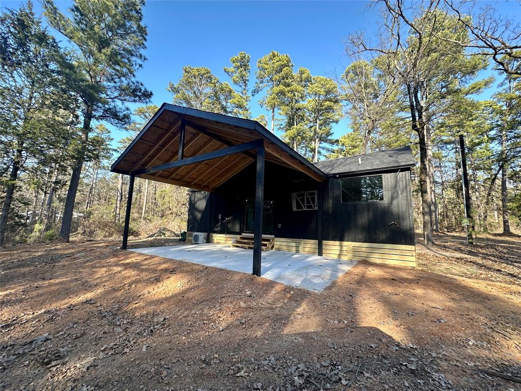 Located in a gated community, this tiny home with 567 square feet sits under towering trees! Have you been dreaming of downsizing or looking for a weekend retreat? In a private community, you'll find community lakes, fishing pier, and clubhouse. For additional privacy, this barndominium-style home comes with 1.38 wooded acres. An open floor, cathedral ceilings, and luxury vinyl plank flooring enhance the living space. The main bedroom is on the 1st floor with two sleeping lofts for the grandkids upstairs. Sip coffee or tea from the pergola-covered front porch deck or on the covered back patio with parking. The kitchen includes butcher block countertops, stainless steel appliances, convection oven, and tile backsplash. Close to city amenities and near the quaint town of Winnsboro, this move-in ready home is the perfect spot for your weekend get-away or permanent residence!