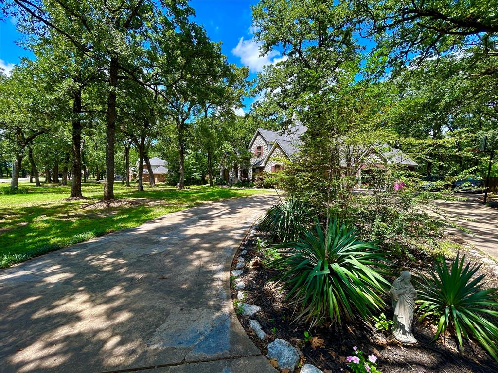 231 Turtle Creek Drive sits on 1.6 private acres in Pleasant Grove Estates, one of Sulphur Springs' well established and sought-after neighborhoods. A winding creek runs along the rear of the property, and towering shade trees provide a cool canopy on summer days. Inside, the primary living room offers a cottage feel with soaring vaulted ceilings, hardwood floors, floor-to-ceiling natural light, and a stone veneer gas log fireplace. The kitchen is designed for real cooking and easy entertaining: granite countertops, an induction cooktop, updated appliances, a center island with a secondary sink, breakfast bar seating, and plenty of cabinetry and counter space. The primary bedroom suite includes a sitting area and ensuite bathroom with a jetted tub, separate shower, dual vanities, an oversized walk-in closet with built-in storage, and an additional secondary closet. The private office has a proper work from home setup and features coffered ceilings and beautiful custom built-in cabinetry. Upstairs, three guest bedrooms share a well-appointed bath with walk-in shower. The utility room is a standout with built-in cabinetry with countertops, a utility sink, full-size washer and dryer space, and a walk-in pantry with room for a standalone freezer. The home also features two flex areas that would be great for a second living area, formal dining, game room, etc. A large deck overlooks the fully fenced backyard where the winding creek and mature shade trees create a naturally private backdrop. A separate dog run adds everyday convenience. Two attached garages include a two-car garage plus a bonus bay that can handle lawn equipment, golf cart, ATV, or shop space. Pleasant Grove Estates offers tree-lined streets, Sulphur Springs ISD schools, and easy I-30 access between Dallas and Texarkana. Cooper Lake State Park and the vibrant downtown square are both minutes away. Homes with this much space, storage, and lot size don't come up often. Schedule your private showing today!