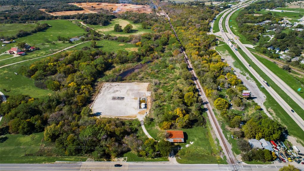 This listing combines 8769 and 102 FM 3136 for a total of 14.01 AG EXEMPT acres right off I35! At the entrance there is a 40x60 metal clad workshop with overhead doors on a concrete slab and there are 2 gas wells located on the southwestern portion of the property. There are typical utility easements and a flood area by a drainage creek. The eastern part of the land borders railroad tracts with Interstate 35 nearby. It is a mixed use area of varying age and size homes and manufactured homes with commercial properties along the highway. Quick commute times to DFW! This property has been used for agricultural purposes but, it would be great for commercial use or possibly to build in rear of property!