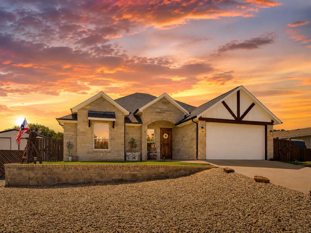 From the moment you arrive, this stunning stone-front home commands attention with its timeless curb appeal and thoughtful architectural details. Situated on a spacious lot in the Sky Harbour community, this 3-bedroom, 2-bathroom home offers 1,473 square feet of beautifully designed living space, combining quality craftsmanship with exceptional functionality. Step inside to an inviting open-concept floor plan where beamed ceilings and gorgeous ceramic tile flooring create a warm yet refined atmosphere. The living area flows effortlessly into the well-appointed kitchen, featuring granite countertops, a gas cooktop, stainless steel appliances, and abundant cabinetry. The private primary suite offers a peaceful retreat with dual vanities and an oversized walk-in shower, while the secondary bedrooms provide comfortable accommodations for family or guests. Outside is where this property truly shines. The expanded covered back patio creates the perfect setting for morning coffee, and outdoor dining. Two gated entries provide convenient access, and a 30 AMP RV hookup offers added flexibility. A standout feature is the impressive 30' x 30' insulated shop with electricity and a 10-foot overhang, providing endless possibilities for hobbies, storage, or a workshop. A loafing shed adds versatility for those with animals or outdoor equipment, while the deep garage and additional side parking ensure plenty of room for vehicles and recreational toys. To complete the outdoor experience, the seller thoughtfully incorporated attractive hardscaping, creating a low-maintenance landscape that enhances both the beauty and functionality of the property. Meticulously maintained and filled with high-quality improvements inside and out, this is far more than a home. It is a property designed to offer comfort, convenience, and the freedom to enjoy your lifestyle. Every detail has been carefully considered, making this a truly exceptional opportunity in Sky Harbour.