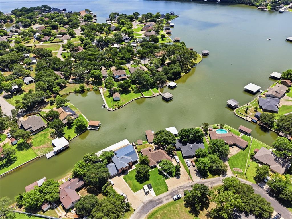 Short Term Rentals OK! You absolutely will not find a better waterfront home at this price!  Clear Deep water! Welcome to your ultimate waterfront escape in the heart of Granbury! This totally renovated three-bedroom, two-bathroom home sits on wide open water with breathtaking big water views that will make every morning feel like a vacation. Whether you're looking for a personal retreat or a turnkey short-term rental investment, this property is ready to deliver from day one. Step inside to discover a beautifully updated interior where modern finishes meet lakeside charm. Every detail has been thoughtfully renovated, creating a space that feels fresh, inviting, and move-in ready. Better yet, nearly all the furniture conveys with the sale, so you can skip the hassle and start living the lake life immediately. But the real magic happens outside. A private boat dock with deep water access means no worrying about shallow spots or seasonal low levels. You'll have plenty of room to launch adventures at a moment's notice.  The subdivision permits short-term rentals (STR), making this a savvy investment opportunity with serious income potential. Imagine guests lining up to book this lakefront gem while you sit back and watch the returns roll in like waves on the water. Opportunities like this don't float by often. Schedule your private showing today and get ready to make a splash!