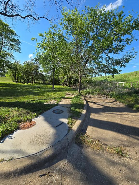 Vacant lot with beautiful greenscape and trees around. Latitude & Longitude is best as there is not a street address marker. Lat 32.76, -96.81. Block 3013. Single Lot number 3. This lot is on an unfinished back way adjacent to I35. It faces the Levee at Millard. Road front description - Private Road.