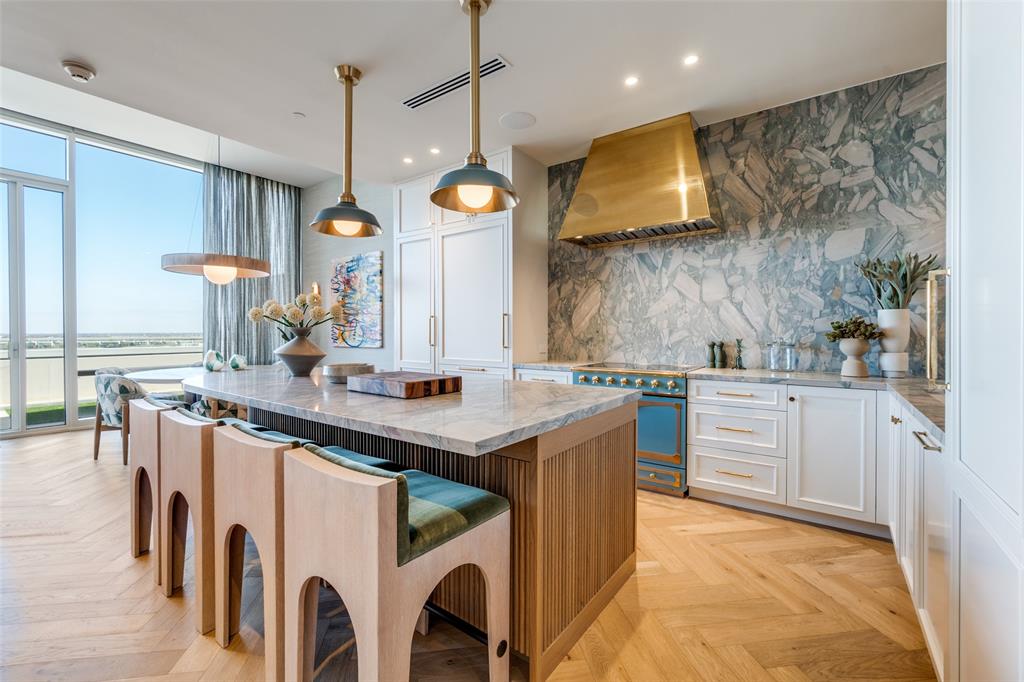 Attention to detail defines this stunning penthouse-level residence in the W Dallas South Tower. Offered fully furnished, this essentially brand-new condominium was completed in 2025 following more than two years of thoughtful, seller-driven custom build-out, with no expense spared to create a highly functional and luxurious floor plan. Highlights include Herringbone European white oak hardwood floors flow throughout the home, complemented by a versatile den ideal for a home office or additional guest room. The chef’s kitchen is a true showpiece, featuring a custom-colored La Cornue French induction range, custom brass metal hood, Sub-Zero refrigerator, and an oversized natural stone island, all seamlessly open to the living area for effortless entertaining. A striking bar area showcases a Cristallo countertop and backsplash, along with a Sub-Zero under-counter beverage refrigerator.The primary suite is a serene retreat, highlighted by grasscloth wallpaper and a spa-inspired bath with marble countertops and a matching marble shower. A dedicated coffee bar with under-counter Sub-Zero refrigeration and a custom-built walk-in closet complete the suite. The spacious guest suite offers its own ensuite bathroom for added privacy. Enjoy outdoor living on the oversized terrace overlooking Victory Park.
Further enhancements include include Lutron lighting throughout, electric shades, and custom drapery, Sonos speakers in every room, LED recessed lighting throughout, custom doors, and designer decorative light fixtures to name a few. The residence includes two assigned parking spaces and offers a true lock-and-leave lifestyle.Ideally located, step outside to premier shops, restaurants, American Airlines Center, Katy Trail, museums, Klyde Warren Park, Uptown, and the Goldman Sachs building.