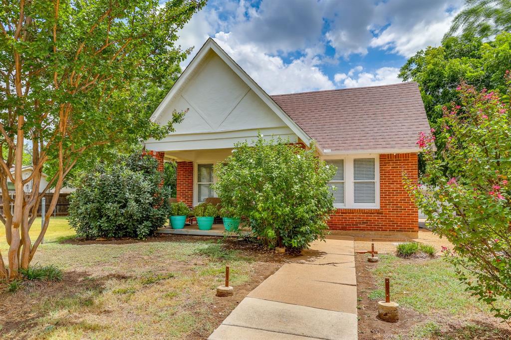 Darling 99 year old Tudor-style bungalow in the Beacon Hill neighborhood in east Fort Worth. This charming red brick home is instantly warm and welcoming with its large front porch and vintage style. The home has been lovingly preserved and features many original details that are impossible to reproduce today. You'll find pristine fluted glass door knobs and brass escutcheon plates with a classic clover design on all the interior doors. The original hardwood floors come with a perfect patina and give the home a cozy vibe. The bathroom features a cast iron claw foot tub and pedestal sink. And the kitchen offers the original hand crafted wood cabinets - complete with a pull out cutting board. Each of the 2 bedrooms has windows on 2 sides and is flooded with natural light. Beyond the original charm - the home offers smart updates like all new pex water supply lines and added connections to allow for a full size stacked washer & dryer unit. Gutters were also added. The home features a detached 2 car garage and an additional stone garden storage shed in the back. The garden shed was crafted by hand many years ago and features fossils and petrified wood in the stone work. The home offers an oversized back yard with plenty of space for gardening or relaxing. Located in the Meadowbrook area of E Fort Worth - only 10 mins to downtown, less than 5 mins to Texas Wesleyan University, 5 mins to Meadowbrook Golf Course and 2 mins to the Tandy Hills Natural Area. So many cute details - come and see it today before its gone!