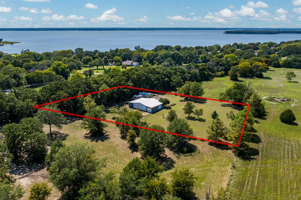 This exceptional approx. 1.55-acre property in Kemp outside city limits offers unparalleled value due to its prime location, nestled just outside highly desirable neighborhoods, 2 of them are gated. Property boasts a spacious 40 x 50 shop with electricity, five doors (two automatic),  Automatic gate, Fenced in, 2 RV hookups with electricity, water and sewer. This unique offering combines the tranquility of a country setting with the convenience of living near a golf course. You could enjoy exclusive amenities of the Cedar Creek Country Club, including a boat ramp, tennis and pickleball courts, a swimming pool, and a clubhouse (with membership). Additionally, the property benefits from Cedar Creek Country Club Water and Sewer access. Easy access to 175.