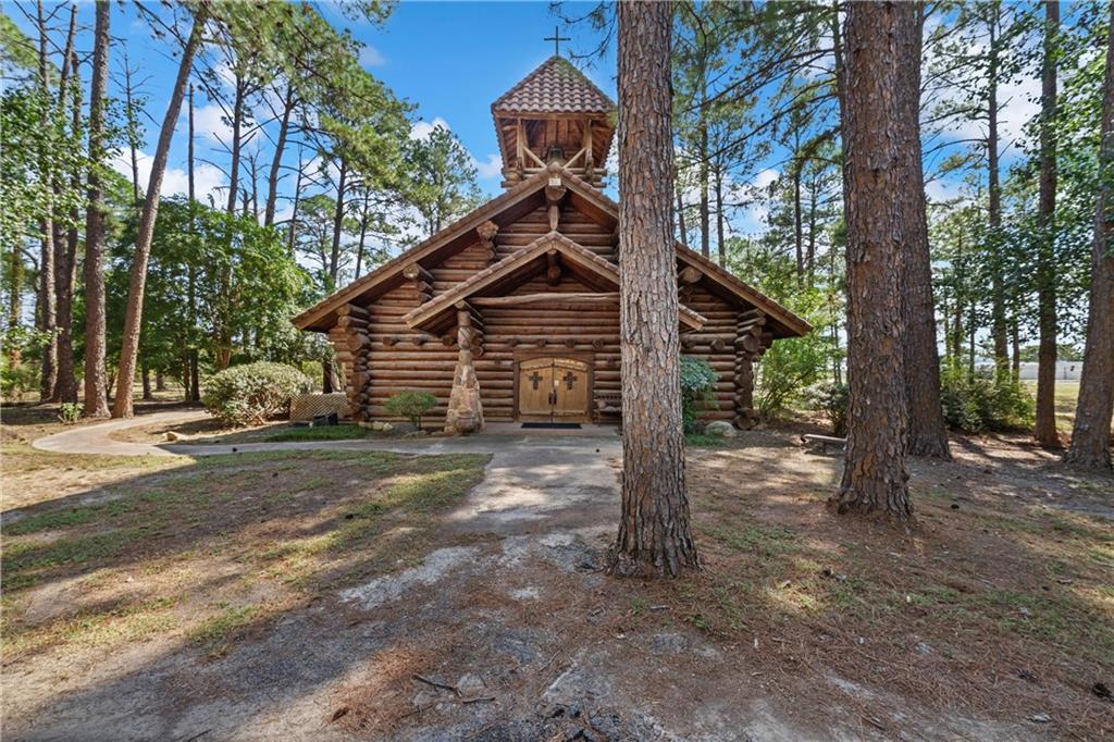 This one-of-a-kind log cabin church sits on 6.5 peaceful acres surrounded by tall pine trees. Built with handcrafted scribed logs, the structure shows off true craftsmanship and rustic charm.

Inside, you’ll find vaulted wood ceilings, exposed beams, and large windows that bring in plenty of natural light. The setting is quiet, shaded, and filled with the scent of pine, making it feel private and calm.

The property is ideal for weddings, events, retreats, or personal reflection. It could remain a church or be turned into a unique venue.

If you’re looking for a special place in the woods with character and natural beauty, this property is worth a look.