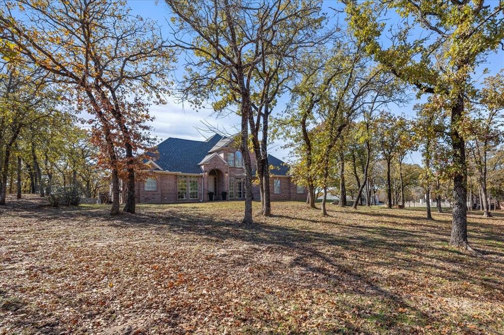 Welcome to 103 Iron Horse Court, set on 2.5 acres of beautifully treed, park-like land. This exceptional estate offers privacy, space, and thoughtful upgrades in a peaceful country setting. Positioned on a corner cul-de-sac lot in a gated community, the property blends everyday comfort with functionality you rarely find.

Inside, the home features an open, well-designed layout with hardwood flooring, granite countertops, and stainless steel appliances. The flexible floor plan includes five bedrooms, with a true owner’s suite on the main level showcasing an updated spa-style bath with separate glass shower. A second downstairs bedroom provides ideal use as a guest suite or multi-generational space. A second living space and office complete the naturally lit downstairs space. 

The backyard is the true showstopper. Surrounded by mature trees, the setting feels private and serene, complete with a covered patio, pool spa combo and room to relax, entertain, or expand. A detached, fully insulated workshop with 220 amp service offers endless possibilities for hobbies, storage, complemented by generous driveway parking and durable, low-maintenance three-board vinyl fencing throughout the property. This is a rare opportunity to own a meticulously maintained property where land, upgrades, and versatility come together effortlessly.