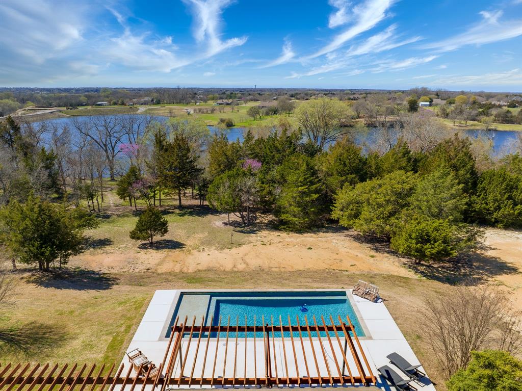 Unveil the splendor of 2451 Marshall Rd., Waxahachie - a haven where elegance intersects with 33 acres of serene landscapes. This exquisite contemporary home is outfitted with the finest Thermador and Viking kitchen appliances, complemented by a Dacor wine dispenser, encapsulating luxury in every detail. The primary bathroom, a masterpiece of renovation, alongside an expansive open-plan living area, sets the stage for grandeur living and entertaining. The outdoors harmonizes with a stunning pool and pergola, overlooking tranquil lake views. The estate is enhanced with a custom chicken coop and ample RV storage, nestled within a property that extends to the other side of the reservoir, ensuring a blend of privacy and natural beauty. Embrace the chance to make 2451 Marshall Rd. your sanctuary, where luxury living becomes your daily reality. Your search ends here with a home not just to be seen, but to be felt and lived in, awaits.