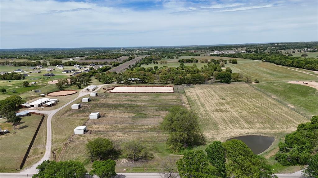 Turn-key 31+ acre horse property built for the performance horse buyer. This ready-to-use setup offers multiple living spaces, quality horse improvements, and room to expand.

The 2022-built ranch-style main home features large porches and refined finishes. A 2 bed, 1 bath guest apartment with large garage space and an additional 1 bed, 1 bath barn apartment provide flexibility for family, hired help, trainers, or rental income.

Horse improvements include a 150 x 320 lighted creosote roping arena, matching warm-up round pen, 120-foot creosote cutting round pen, and a main barn with 6 stalls, 3 runs, tack room, feed room, and heated wash rack. The property also offers 7 large cross-fenced turnouts with loafing sheds, 2 of which are heated, and all have electricity. Two coastal pastures with a pond add to the functionality.

Additional improvements include a separate office behind the barn, 4 RV plugs, 2 water wells, and an utilities in place for an additional dwelling.

Well-equipped and ready to use, this is a strong setup for training, operating, or enjoying horses in the Horse Capital of the World.