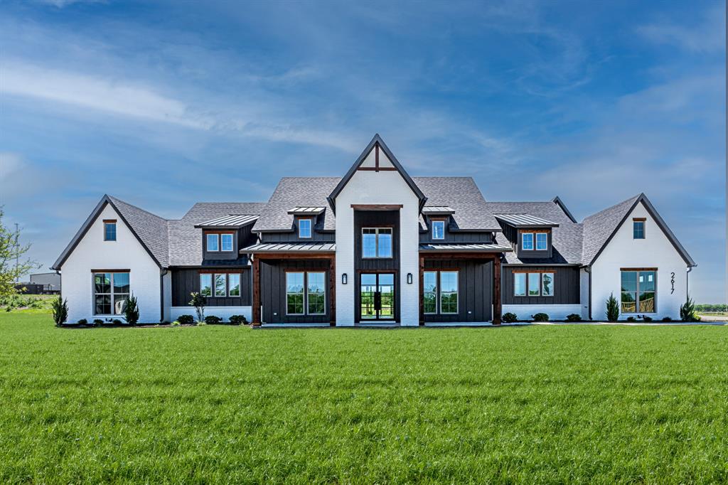 Step into upscale Texas living in this stunning 4-bedroom, 4.5-bath custom masterpiece on nearly an acre in the exemplary Argyle ISD. Thoughtfully designed for both everyday comfort and unforgettable entertaining, the open-concept effortlessly connects the kitchen, dining, and living spaces in a light-filled, welcoming layout. The kitchen features an oversized island with built in 60” refrigerator, pro-style range and microwave drawer. Walls of glass—anchored by 16’ Bi-fold doors that open to the expansive covered rear patio create a seamless indoor-outdoor lifestyle perfect for entertaining. Enjoy evenings by the wood burning outdoor fireplace, with a gas and water stubbed out ready for your future outdoor kitchen, all overlooking an open backyard retreat. The great room commands attention with a contemporary sleek linear electric fireplace with built-ins and floating shelves. Every detail reflects refined craftsmanship with the custom wine room, floating shelves, engineered white oak wood floors, quartzite countertops, and carefully curated designer lighting with champagne bronze plumbing fixtures. The chef’s kitchen is as functional as it is beautiful, featuring a spacious walk-in pantry with custom cabinetry, while the dining area is enhanced by a stylish built-in wine bar—perfect for entertaining. The primary suite is a true sanctuary, offering a spa inspired walk in shower with dual shower heads, a stand alone bath tub and a large custom walk-in closet with island designed for luxury living. The home also includes a secondary en-suite, private office, and two additional bedrooms with ensuite bath ideal for guests or multigenerational living. This is more than a home—it’s a lifestyle defined by elegance, space, and exceptional design. The home has been completed and is Move in Ready.