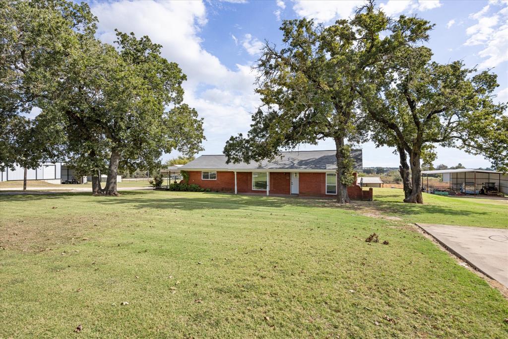 This stunning 3.1 acre property has a multitude of possibilities with a charming 3 bedroom and 2 bathroom house. The house has been newly remodeled with beautiful granite countertops and lovely two-toned farmhouse style kitchen cabinets. Both bathrooms are spacious with walk in showers and plenty of countertop space. Quaint breakfast nook as well as an air-conditioned sunroom both with lots of natural light and a perfect view of the arena. Arena is equipped with roping boxes and chute as well as a couple of nice size traps for horses and cattle. Just above the arena is 50 ft by 60 ft equipment barn that could house equipment, hay and feed or easily be converted into a horse barn. There is also a 40 ft by 40 ft building that is currently be used as a tack room plus well house. Towards the front of the house to the right is a small rustic building with lots of potiential and a metal shed tall enough to park a trailer or RV. The highway frontage of this property would make this perfect to have your business in or rent it out to another business and have the convenience of managing everything right in your own backyard. Either way you look at this entire property it has great potential to be an income driven home. Schedule a time with me and let's go take a look at your next dream property.