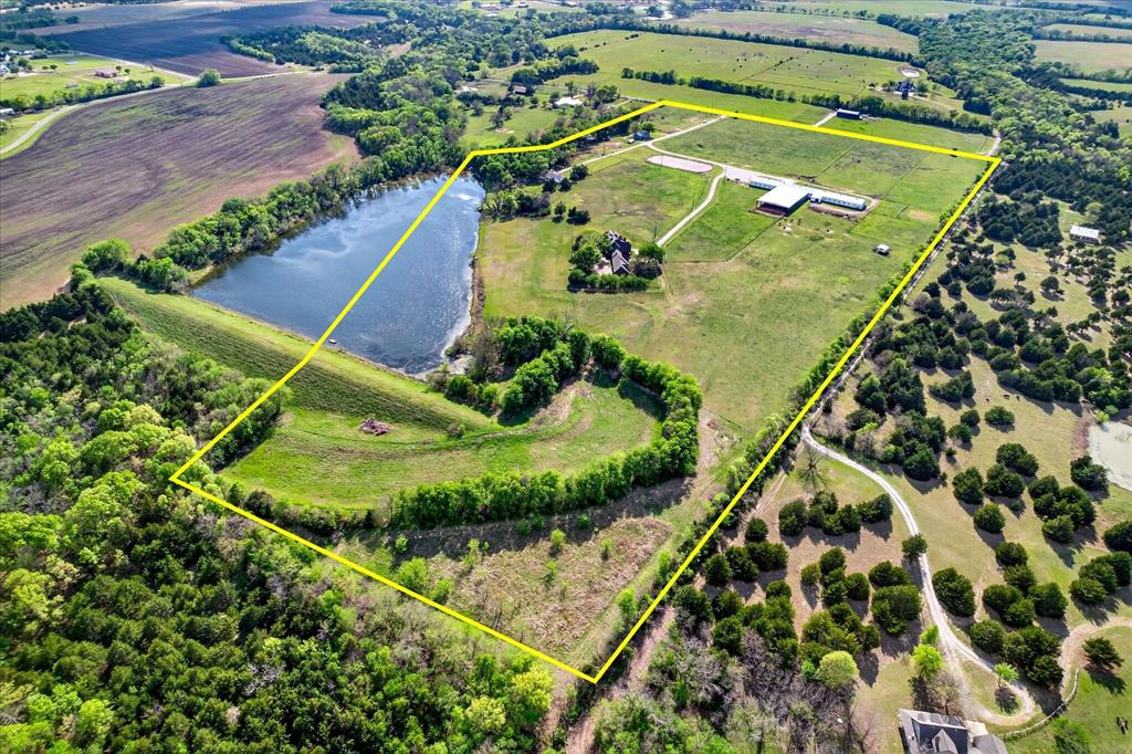 ESTATE with STRATEGIC FLEXIBILITY awaits in the heart of North Texas’ highly sought-after Collin County - perfectly positioned between future DNT, Preston Rd and I-75., 49.7 ACRES is located in rapidly expanding Celina - Anna area. ACREAGE IS VANISHING as growth moves north and sizable tracts are absorbed and subdivided. Securing 40+ contiguous acres with significant existing improvements this close to the city’s expansion path is increasingly rare!! 
This gated 5,000 sq ft country estate rests on 49.7 serene acres, offering sweeping views of a pool-spa and beautifully stocked 7-acre shared lake that feels like your own private escape. Inside, the main floor welcomes you with a gourmet kitchen, a spacious primary suite with a cozy fireplace and sitting area, and an inviting gathering room complete with a walk-in wet bar and fireplace. A richly paneled library - also with its own fireplace - provides an inspiring space for a home office or an additional bedroom. Upstairs, two charming bedrooms open to a balcony overlooking expansive, breathtaking vistas.
Across the port-cochere, guests can enjoy a private 2BR-1BA guest house with its own living area and kitchenette—perfect for  family, extended stays, or income-producing potential. The property also includes a 3-bedroom manufactured home ideal for a caretaker.
Equestrians will appreciate the impressive 300 ft Morton barn with 40 stalls, a temperature- controlled lounge with kitchenette, office, and full bathroom, plus a connected, covered and lighted 80x160 arena. An additional 90x180 outdoor lighted arena offers even more space for training and events. 
Currently operating as an income-producing full-care horse facility.Whether you're seeking a personal sanctuary, a thriving business venture, or both—this estate offers unmatched possibility wrapped in peaceful Texas charm. NOTE: ASK agent about additional unlisted tracts of adjacent land for purchase!