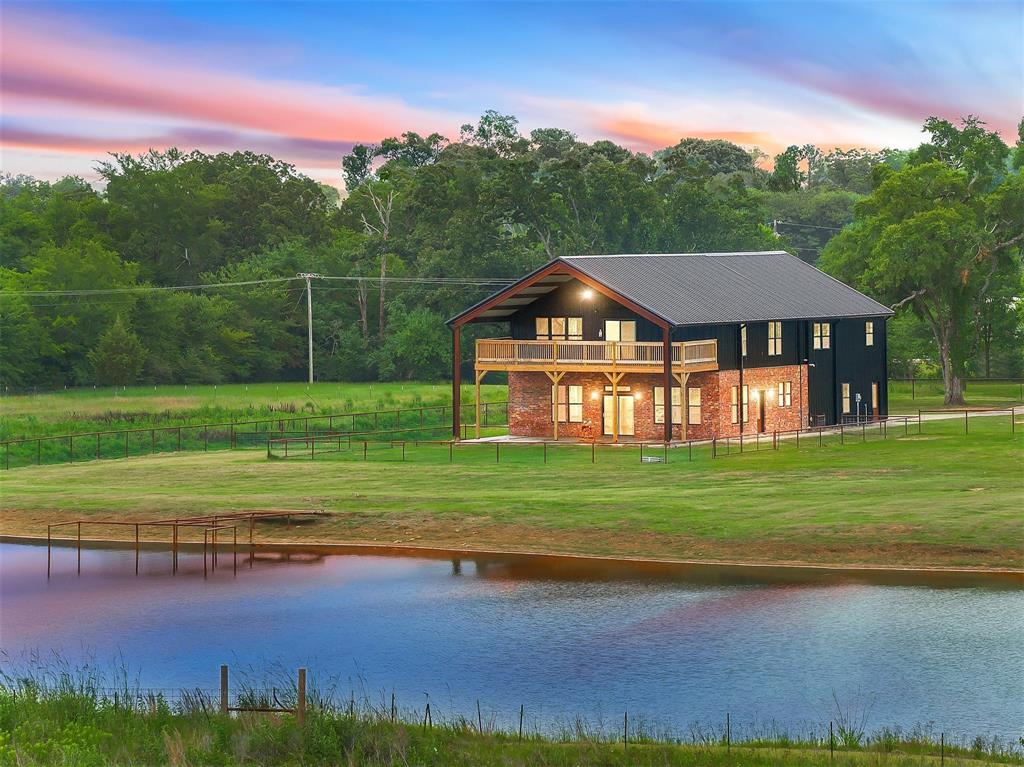 The land is ready. The pond is stocked. The house is almost finished. Now it's your turn! Situated on 16 acres, this custom-built barndominium is nearing completion and offers a rare opportunity to own a brand-new home while still having a say in the final details. Never lived in, this one of a kind property allows buyers to select finishes such as the primary bathroom vanity, tub, lighting fixtures, and a few remaining touches to truly make it their own. Designed with both functionality and character in mind, this 5 bedroom, 4 bath home features soaring ceilings, custom finishes, designer tile work, luxury vinyl plank flooring being installed, and an open-concept layout ideal for everyday living and entertaining. The kitchen offers custom cabinetry, quartz countertops, and a large island overlooking the living and dining areas. The primary suite was designed as a true retreat with an oversized walk in shower and space for the tub of your choice. Upstairs, you'll find additional bedrooms, living space, and some of the home's most memorable features, including both a staircase and a slide connecting the two levels, along with two built-in children's hideouts play lofts that are sure to spark imagination and adventure. Outside, the property is just as impressive. A 1,200-square-foot attached three-car garage with spray foam insulation provides ample space for vehicles, storage, hobbies, or a workshop. The 36x50 barn offers even more versatility for equipment, livestock, projects, or recreational use. The acreage is fenced and cross-fenced with pipe fencing and pipe gates surrounding the home, creating a clean, polished look while providing functionality for animals and country living. A chicken coop with a fully fenced chicken run is already in place, making it easy to step into the lifestyle you've been dreaming about. With room to roam, fish, raise animals, and enjoy the peace of East Texas living, this property offers the kind of lifestyle many people dream