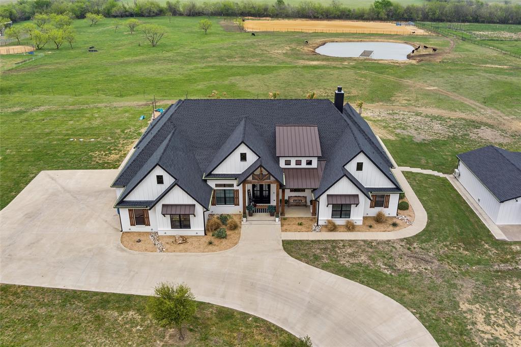 Welcome to a one-of-a-kind estate where luxury meets country charm on over 15 pristine acres in the heart of Maypearl. This custom modern farmhouse is packed with high-end finishes and thoughtful features, designed for both comfort and functionality.

The main home features ensuite bathrooms in every bedroom, giving each family member or guest their own private retreat. Soaring ceilings with exposed wood beams, a stunning stone fireplace, and expansive windows flood the living spaces with natural light and countryside views. The gourmet kitchen is a showstopper with Wolfe brand appliances, commercial-grade Sub-Zero Wolf refrigeration, and a massive island perfect for gathering and entertaining.

Step outside to find a fully fenced and cross-fenced property, ideal for livestock or equestrian use. You’ll also love the resort-style pool and spa, and a spacious covered patio that’s ready for entertaining or relaxing with sunset views.

But that's not all—this property includes an incredible barndominium featuring 2 bedrooms, 1 full bath, a full kitchen with granite countertops, and a cozy living area. Perfect for guests, in-laws, or rental potential.

Looking for a space to unwind or entertain? You’ll also find a detached game room complete with a built-in man cave—the ultimate bonus space! The home features a 10 stall barn with an extra apartment and bathroom. Also features a riding arena and pond. 

This property truly has it all: luxury, space, privacy, and versatility—just 45 minutes from DFW. Come experience what ranch living should feel like.