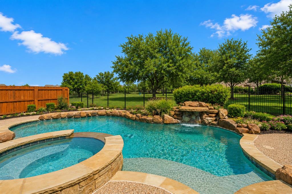 Motivate Seller!! Stunning Highland home with sparkling pool and spa in sought after LaCima subdivision of Stonebridge Ranch. Imagine coffee on your front porch every morning and cooking with friends on the back porch in the early evening. Premium greenbelt lot with panoramic views, built in outdoor cooking area, pool and spa, and waterfall on almost a quarter of an acre.  This lovely home has 5 full bedrooms with primary and full guest suite located downstairs.  Popular floorplan with spacious chefs kitchen with double ovens, large island, a butlers pantry, large walk in pantry and gas cooktop. Hardwood floors through the entertaining spaces downstairs. 4 living areas including a formal living room, family room, gameroom and media room.  Downstairs living space has a beautiful stone fireplace and custom built in with view of the pool and spa.  Primary bedroom has a sitting area overlooking the greenbelt. AMAZING primary bathroom has been completely remodeled. Your private RETREAT awaits ! Stonebridge amenities include beach lagoon pool, splash pad,  tennis and pickleball, basketball courts, parks, walking trails and ponds. 2 AC units replaced 2021 and water heater converted to tankless in 2020. Several rooms recently painted and all upstairs carpet replaced. NO MUD OR PID IN STONEBRIDGE