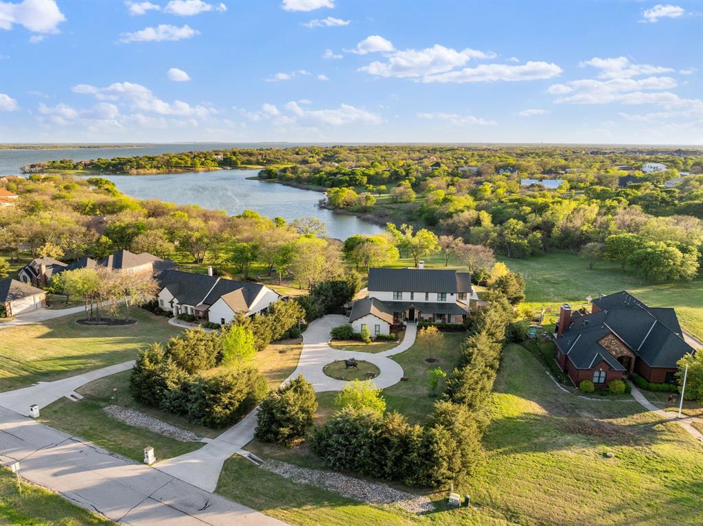 A Lakefront Lifestyle Like No Other — Little Elm, TX
4 bed  4 full  2 half bath · 4,860 sq ft   1.27 acres · 120+ ft of Lake Lewisville waterfront · $2,800,000 

Set quietly along the shores of Lake Lewisville in Little Elm, Texas, this extraordinary 4,860-square-foot luxury home sits on 1.27 private acres with over 120 feet of protected waterfront, a rare offering in Denton County at any price.  

Arrive through a sweeping circular drive to a 49-foot front porch that stretches the full width of the facade — the kind of first impression that slows you down immediately. Inside, rich wooden beams frame generous living spaces, while leathered granite surfaces and curated finishes deliver a refined yet relaxed elegance. All four bedrooms feature private en-suites, giving family and guests comfort and autonomy throughout.

Outdoors is where this lakefront property truly distinguishes itself. Nearly 3,000 square feet of pool decking anchors four distinct outdoor living areas, each designed for a different moment in the day. Three screened-in porches let you enjoy the lake breeze uninterrupted. A private courtyard offers a quiet retreat. And a 36-foot covered terrace frames sweeping views across the pool, the tree line, and the water beyond — front-row seats to some of the most spectacular sunsets in North Texas.

Evenings here don't end, they unfold. Whether you're hosting under the stars, out on the water, or simply settling into the stillness, this home delivers a lifestyle that feels both elevated and grounded.

Additional features include a durable steel roof, plantation shutters throughout, a dedicated media room, a European-style wet shower, and unobstructed greenbelt views that ensure lasting privacy. Just minutes from Cottonwood Creek Marina and the Little Elm Beach boat ramp.

This is more than a lake house, it's a private retreat where nature, design, and lifestyle converge. Schedule your private showing today.