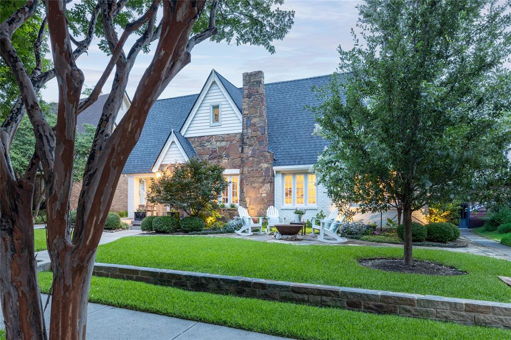 Step into a world where 1920s Tudor soul meets uncompromising modern luxury. This meticulously reimagined Greenland Hills residence honors its historic roots while delivering a sophisticated interior defined by world-class finishes and designer curation. From the classic arched entry to the sun-drenched living spaces, every inch of this home reflects an elevated aesthetic.

The heart of the home is a true culinary masterpiece. The gourmet kitchen, anchored by premium appliances and custom cabinetry, flows seamlessly into a chic wet bar. Outfitted with illuminated display cases, a wine refrigerator, and an ice maker, it’s a space designed for effortless hosting. Throughout the home, the attention to detail is palpable, featuring exquisite Ann Sacks and Walker Zanger tilework, complemented by high-end fixtures and lighting from RH and designer lighting by Visual Comfort.

The second floor is dedicated to a sprawling primary sanctuary that redefines luxury. This private retreat includes a spacious sitting area and an ensuite bath featuring dual vanities, a freestanding soaking tub, and an oversized shower. Beyond the massive custom walk-through closet lies a tucked-away private office, offering a quiet, sophisticated workspace. Two additional bright, beautifully appointed bedrooms and an updated bath reside on the main level.

Transition outside to a spectacular outdoor living room that serves as a year-round destination. Under a custom wood-plank ceiling, you can gather around the towering stone fireplace while overlooking professionally landscaped grounds and raised garden beds. The property is completed by a charming gardener’s shed and an oversized garage that offers incredible storage or the potential for a future guest suite conversion. This is a rare opportunity to own a piece of Dallas history polished to a contemporary shine.