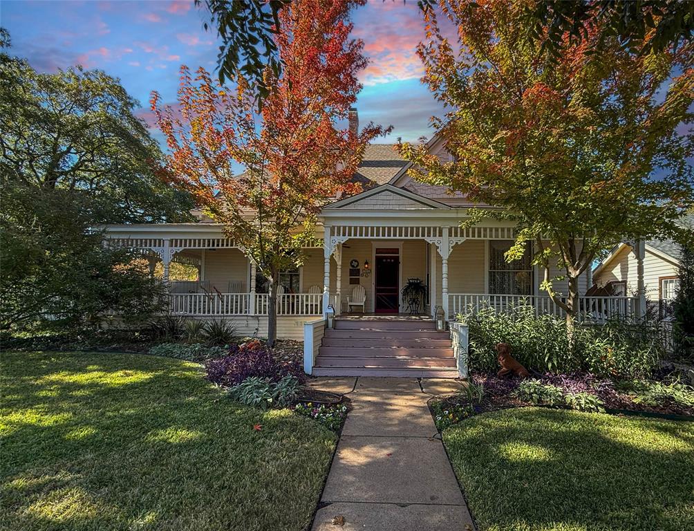 Welcome to The Estes House, an extraordinary Queen Anne Victorian built in 1897 and beautifully preserved as one of Historic McKinney’s most iconic residences that holds County, State and National Markers. This 5-bedroom, 5-bath estate masterfully combines timeless craftsmanship with modern luxury, offering an opportunity to own a piece of McKinney’s rich history just blocks from the vibrant Downtown Square. From the moment you step onto the gracious wraparound porch, you’ll feel the hospitality that define this historic home. Inside, the majestic entry reveals intricate Victorian woodwork, original longleaf pine floors, and period light fixtures that tell the story of another era. Grand formal living and dining rooms feature elegant moldings, tall ceilings, and multiple fireplaces that invite special gatherings. The chef’s kitchen is a dream for entertaining and dinner parties, featuring premium appliances, custom cabinetry, generous counter space, and seamless flow into dining and outdoor areas. Two primary ensuite bedrooms, one on each level, provide comfort and flexibility for guests or multigenerational living. The spacious upstairs primary suite offers a tranquil retreat with a copper soaking tub, walk-in shower, and luxurious finishes reminiscent of a boutique spa. Meticulous care has been taken in the restoration and modernization of this home, including added insulation, a floored walk-in attic, window inserts providing both sound and thermal insulation, whole-house surge protection, built-in sound system, and comprehensive Wi-Fi coverage throughout. Step outside to your private backyard oasis with a saltwater pool, surrounded by lush landscaping and privacy fencing-perfect for relaxing or entertaining. A three-car garage, rare in the Historic District, adds convenience without compromising the home’s period charm. 903 N College embodies the essence of Historic McKinney living-a seamless blend of history, beauty, and modern comfort in one remarkable estate.