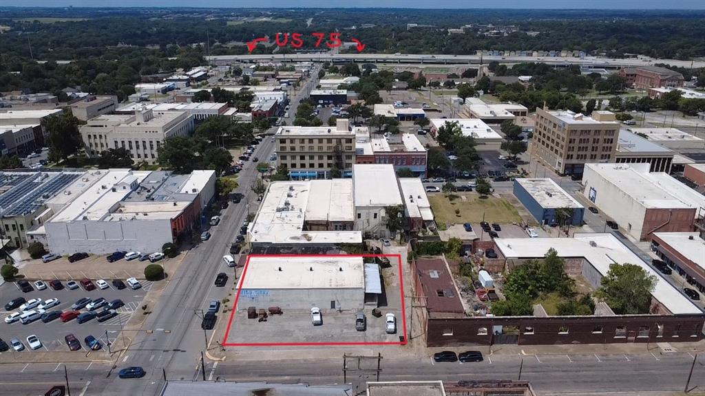 Now is the time to buy in up-and-coming Sherman, Texas!  Offering investors or business owners an incredible opportunity for an unlimited number of business uses, this C-2 Commercial zoned property allows a wide range of retail and wholesale uses in addition to all permitted C-1 uses. The one-level 5,000 sf building space has an ideal large open configuration; interior walls could be easily erected to fit specific purposes. Currently, there is a non-structural framed sheetrock wall separating approx. 40% of the square footage in the back. Perimeter walls are original brick with plaster overlay and a few areas where brick has been intentionally exposed for aesthetic purposes.  Two functional bathrooms in front and two plumbed bathrooms without fixtures in back. Building and property have been well maintained. A ramp and loading dock with an 8' rollup door provides easy delivery access. Adding exceptional value, the second parcel in this sale is the adjacent 5000+ sf parking lot. All information presented deemed to be reliable, but buyer and their agent must verify accuracy of any and all information.