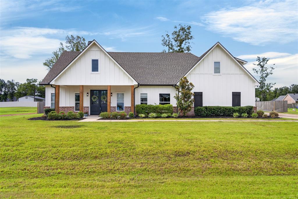 Discover this newly built 5-bedroom, 3-bathroom home, set on over half an acre in Stonewall, LA. Constructed in 2023, this property embodies sophistication and comfort, perfect for those seeking a serene lifestyle. The heart of this home is its open-concept design, highlighted by a spacious kitchen and living room. The kitchen boasts a large island, stainless steel appliances, granite countertops, and a striking tiled backsplash, making it both stylish and functional. The living room, adorned with exposed cedar beams, offers a warm and inviting space for relaxation and entertainment. The thoughtfully designed layout features a private primary suite that promises tranquility and luxury. Enjoy the expansive walk-in shower, large soaking tub, dual vanity sinks, and a sizable walk-in closet conveniently connected to the laundry room, providing ultimate convenience and space efficiency.
Two guest bedrooms are located on one side of the home, accompanied by a full guest bathroom. A versatile room off the living area, currently used as a playroom, offers potential as an additional bedroom or flexible space. Upstairs lies a guest bedroom suite, complete with its own full bathroom, offering privacy and comfort. Exterior spaces are perfect for outdoor enjoyment and entertaining. The large extended patio at the back of the home is ideal for gatherings, while an extended driveway leads to the double car garage, enhancing both accessibility and curb appeal. This property combines luxury, flexibility, and convenience, offering everything needed to accommodate a variety of living needs. Come explore this beautiful home in Stonewall and experience the possibilities it presents for a refined and relaxed lifestyle.